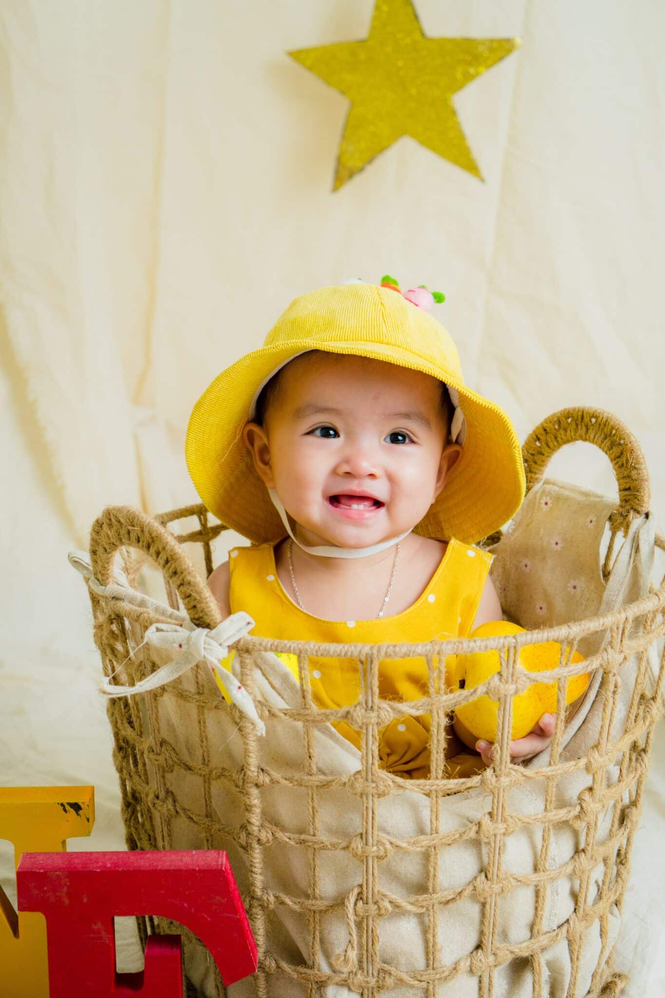 cute baby girl sitting inside the basket