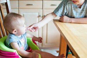 Pediatric Nutrition: Building Healthy Eating Habits with Your Pediatrician's Help 4 older brother giving candy to sibling-healthy eating