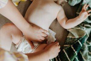mother changing the diaper of baby