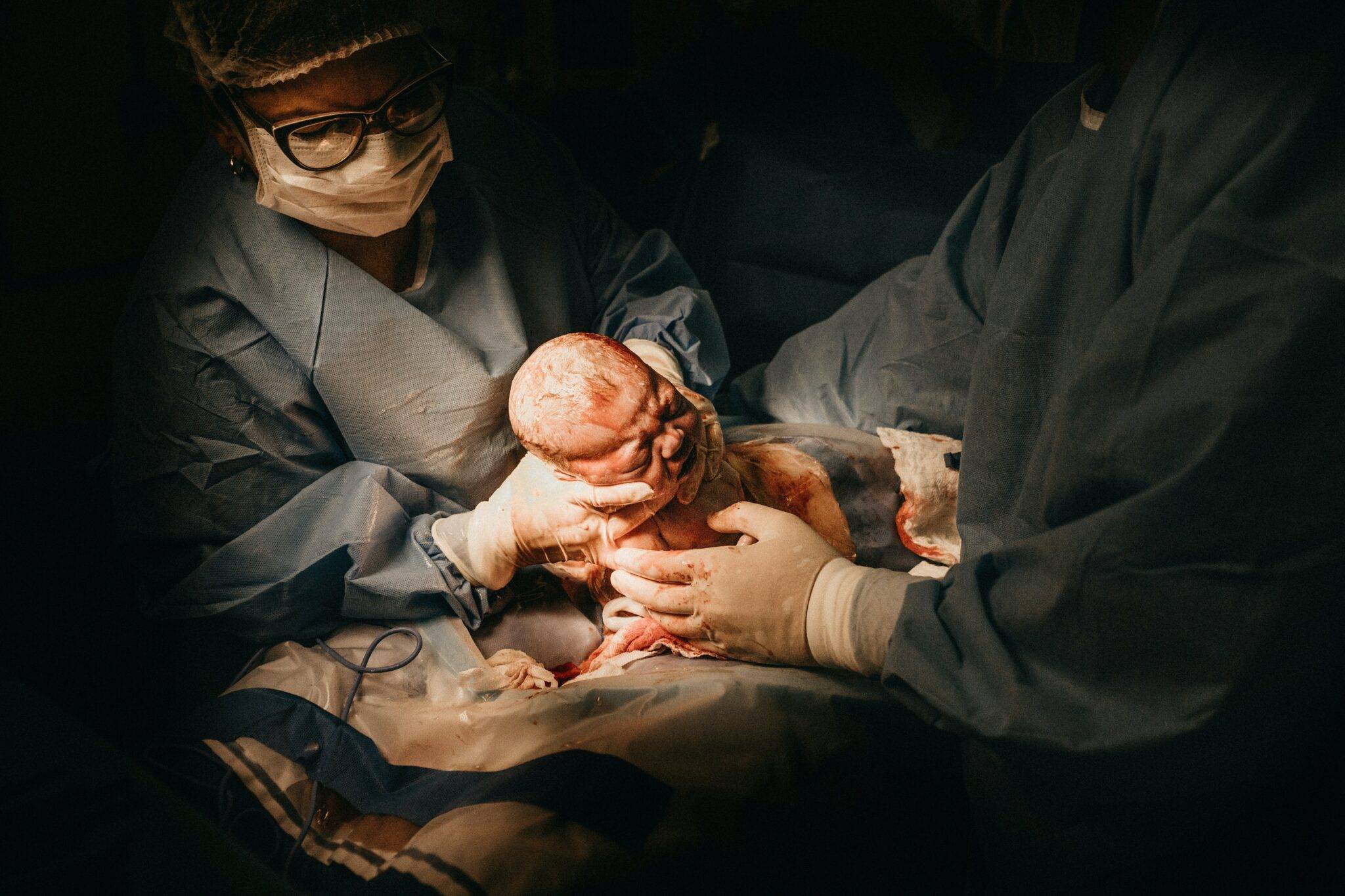 newborn baby held by doctors