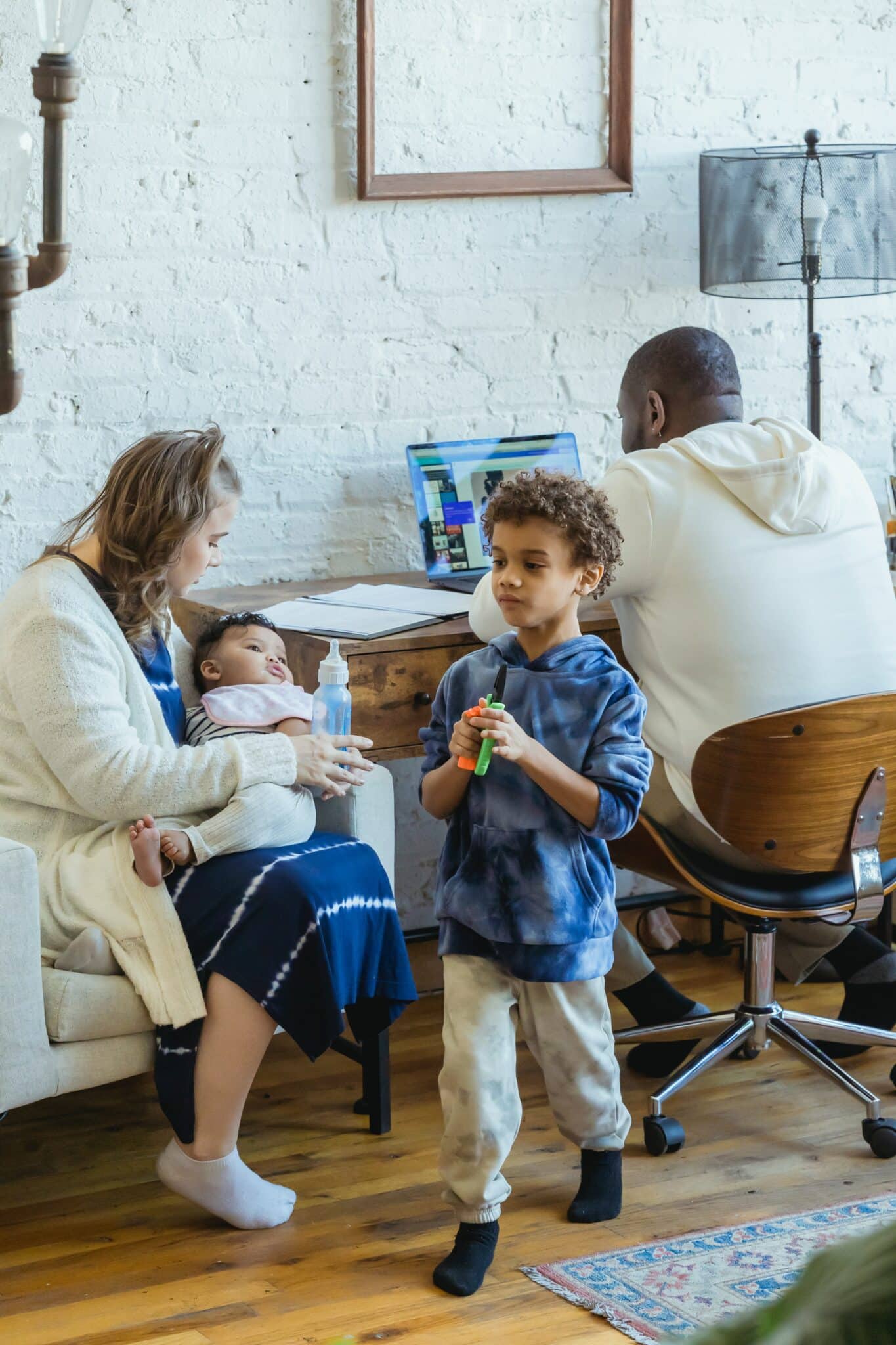 lgbt-friendly-pediatrician-UTI mother sitting on chair holding a bottle of milk for baby-after-hours-pediatrics