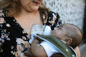 baby drinking milk on a bottle Baby Formulas