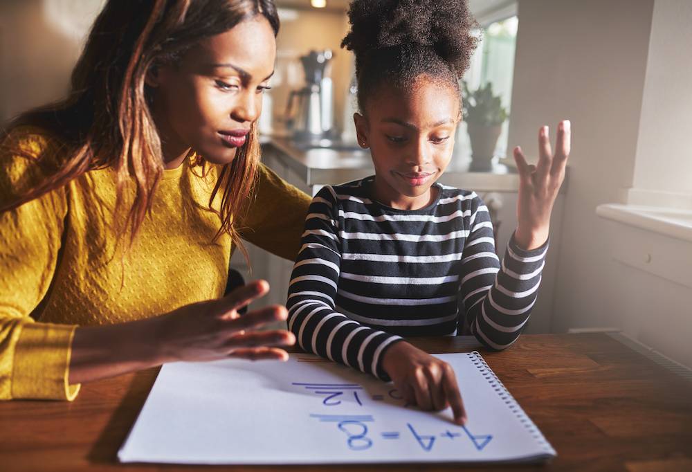 Mother learning child to calculate, black mother and daughter school anxiety